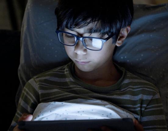 boy wearing eyeglasses using a digital tablet